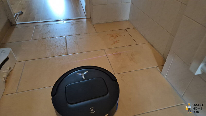 Der ECOVACS DEEBOT T80 OMNI wischt eingetrockneten Ketchup von einem Hartboden.